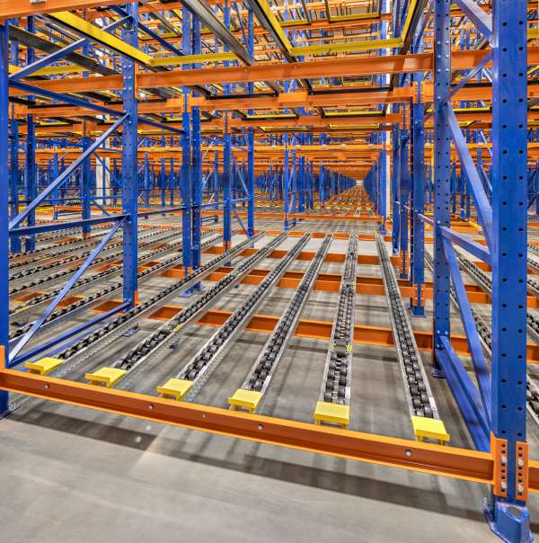 Pallet flow rack system with roller conveyors in warehouse