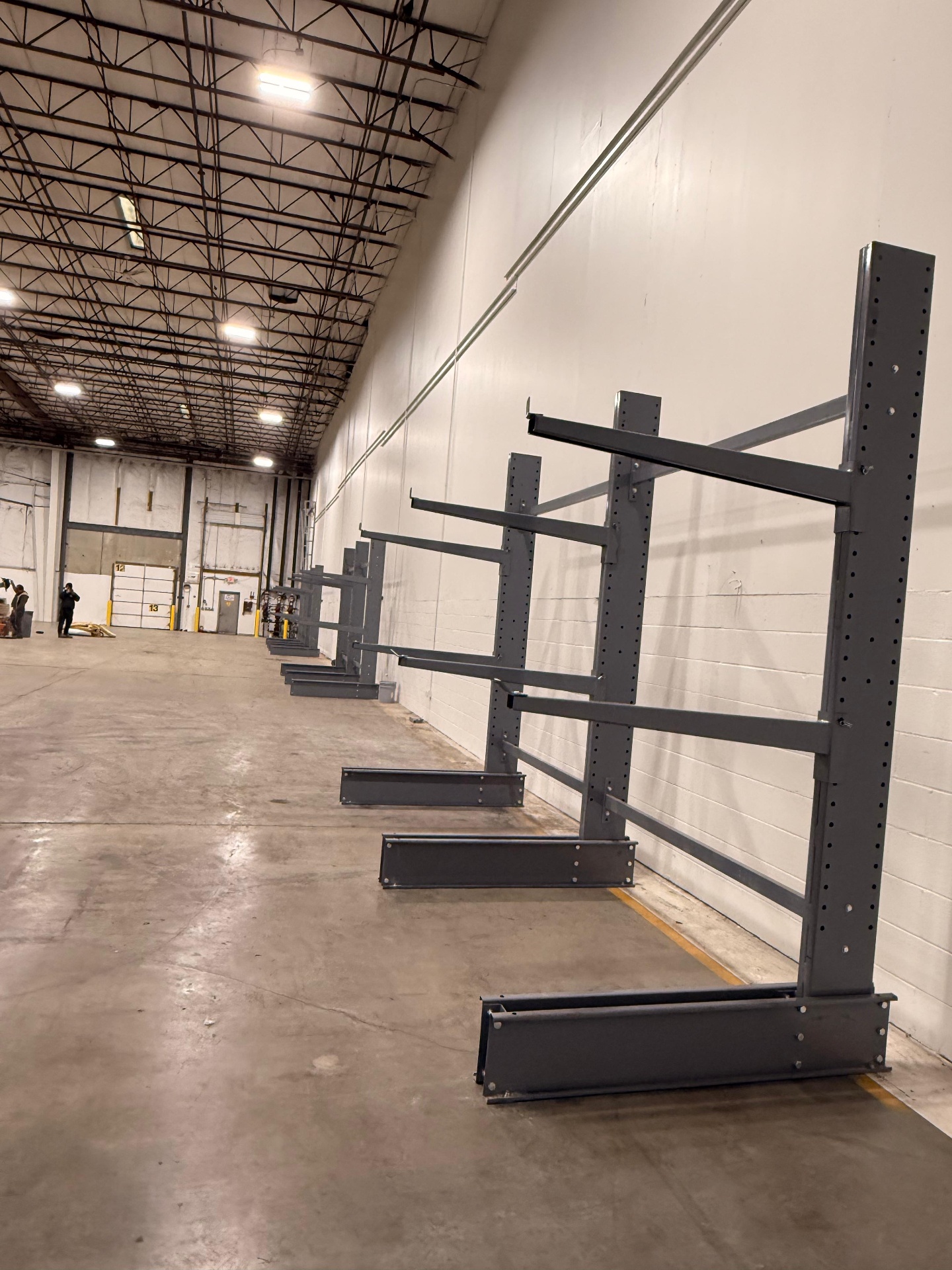 Single-sided gray cantilever racking installed along warehouse wall for long-load storage