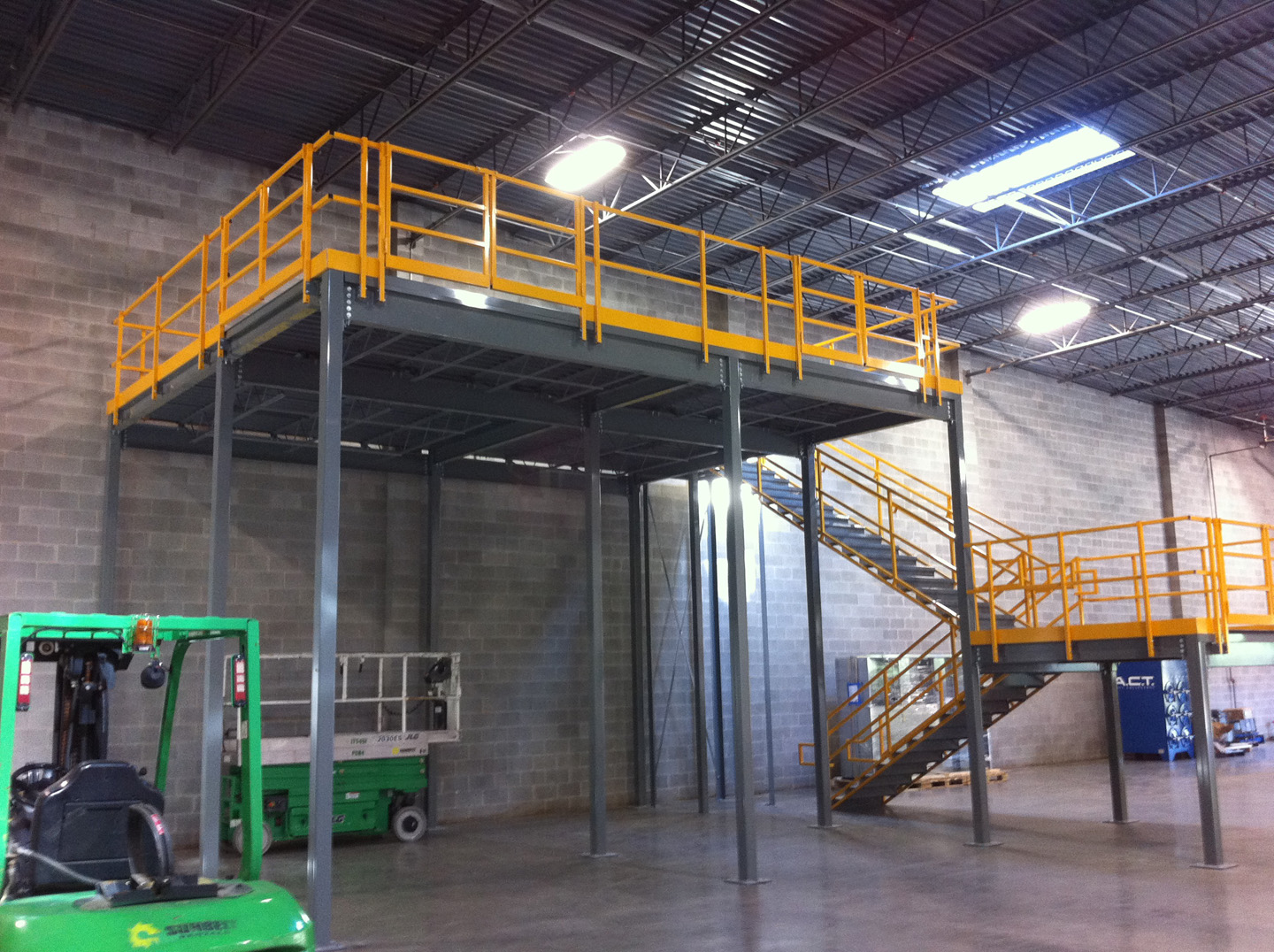 Tall mezzanine system with yellow railings and staircase in Cincinnati OH warehouse