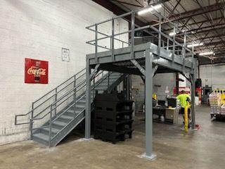 Steel mezzanine platform with staircase installed at Coca-Cola warehouse facility