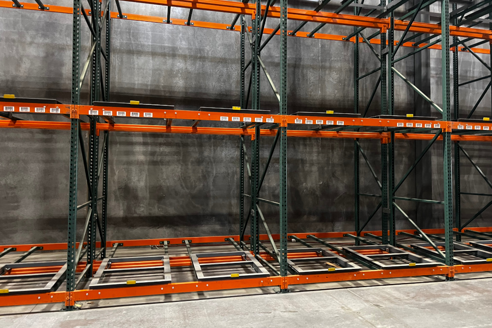 Pushback pallet racking with cart rails and orange beams