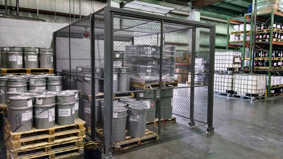 Wire mesh security cage with stored materials in warehouse